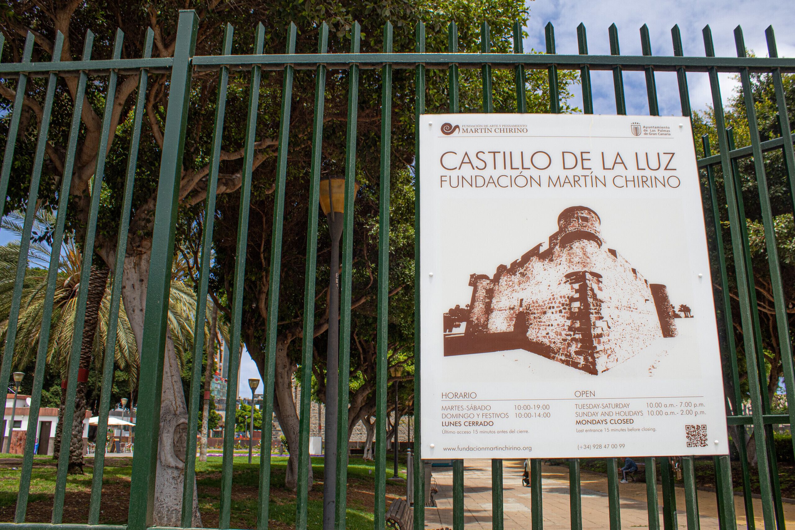 Un panneau indiquant les heures d’ouverture et l’adresse du site web de la fondation Castillo de la Luz Martin Chirino.