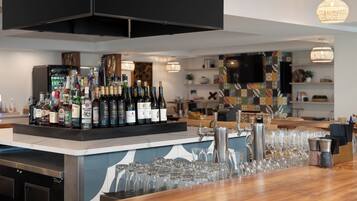A bar area with a variety of bottles and glasses.