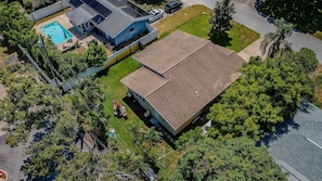 A residential property with a swimming pool, a covered patio, and a large garden area.
