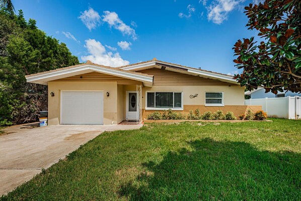 A single-story house with a garage, a front porch, and a well-maintained lawn.