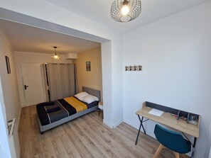 Une chambre à coucher de taille réduite, comprenant un lit, un bureau et une chaise.