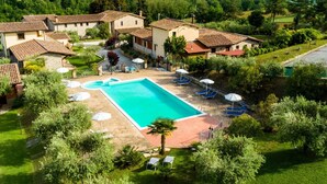 Un complexe hôtelier doté d’une piscine, de chaises longues et offrant une vue sur la campagne environnante.