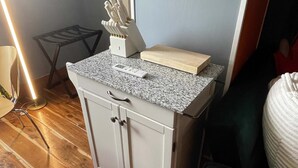 Una cocina con encimera de granito, tabla de cortar de madera y bloque para cuchillos.