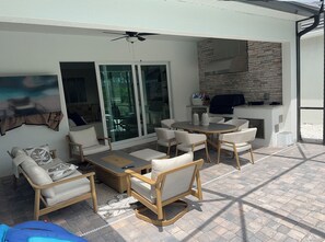 Relax and socialize in this inviting patio area with a sofa, chairs, and table, perfect for outdoor dining and enjoying the view.