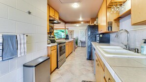 Una cucina moderna con mobili in legno, elettrodomestici in acciaio inossidabile e un lavello capiente.
