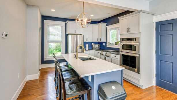 A modern kitchen with white cabinets, stainless steel appliances, and a central island with bar stools. - Pet-Friendly Lancaster Home 13 Mi to Dtwn Buffalo (Lancaster)