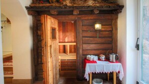 Une pièce rustique en bois, avec un lit en mezzanine, une table avec des tasses et une bouilloire, et une fenêtre donnant sur un paysage agréable.