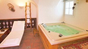 Une pièce avec une échelle en bois, une grande baignoire, un banc et une fenêtre donnant sur un beau paysage.