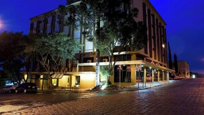 A multi-story hotel with a ground-level entrance, large windows, and a paved street in front. - Planalto Hotel (Canoinhas)