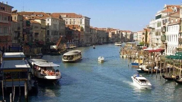 Un canal con barcos y edificios a lo largo de sus orillas.