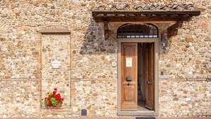 A stone building with a wooden door and a small flower box.