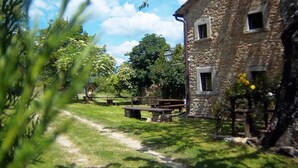 Un edificio de piedra con zona de picnic y cielo despejado.