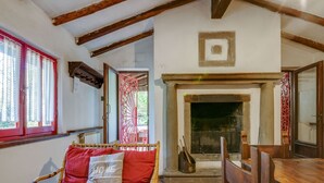 Una habitación acogedora con un sofá de mimbre, una mesa de madera y una chimenea.