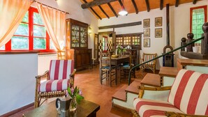 A cozy room with a wooden ceiling, a dining area with a table and chairs, and a window with curtains. - Beautiful vacation home (Migliorini - Pistoia)