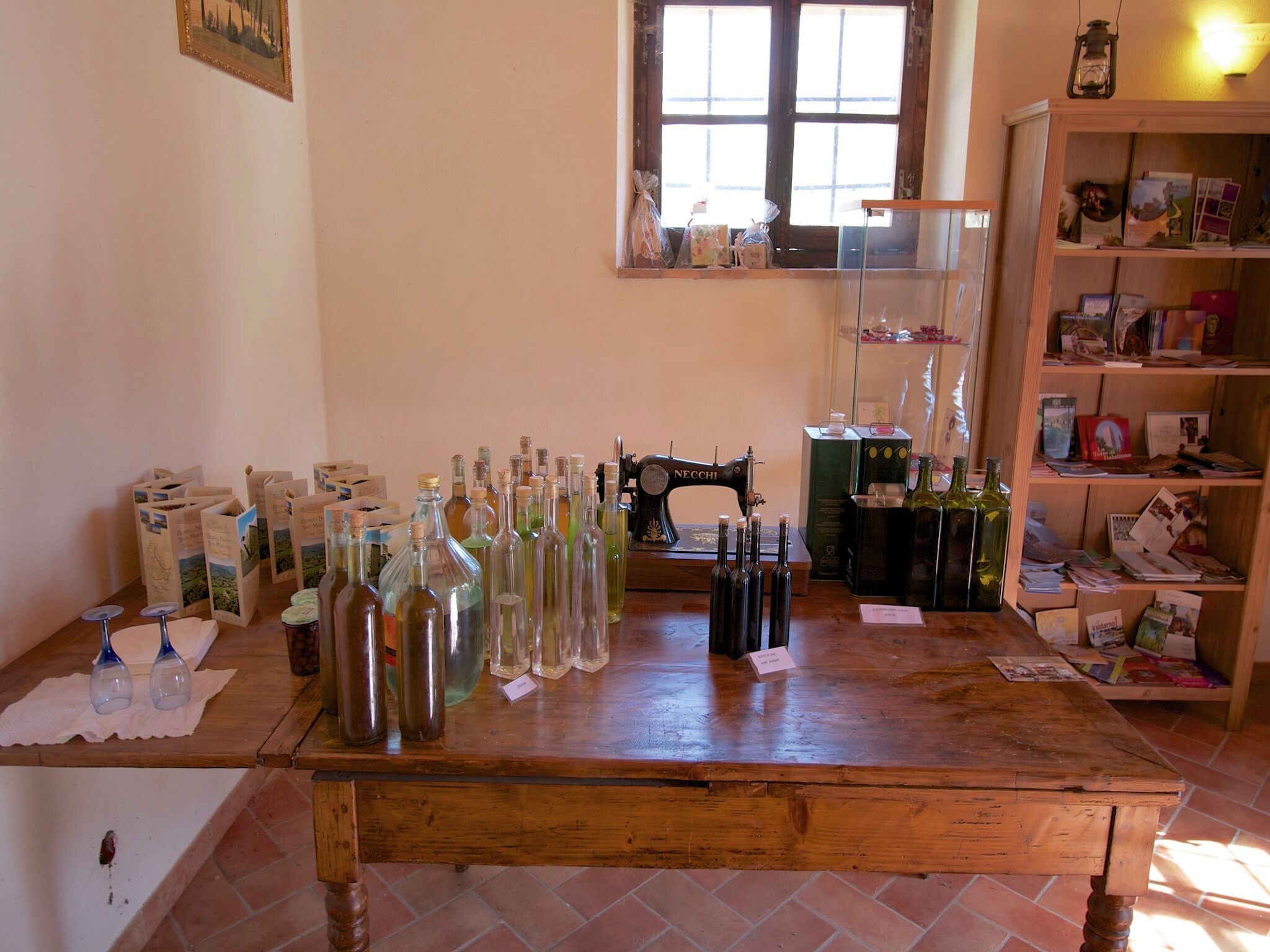 A rustic wooden table with various bottles and boxes, a sewing machine, and a window with natural light.