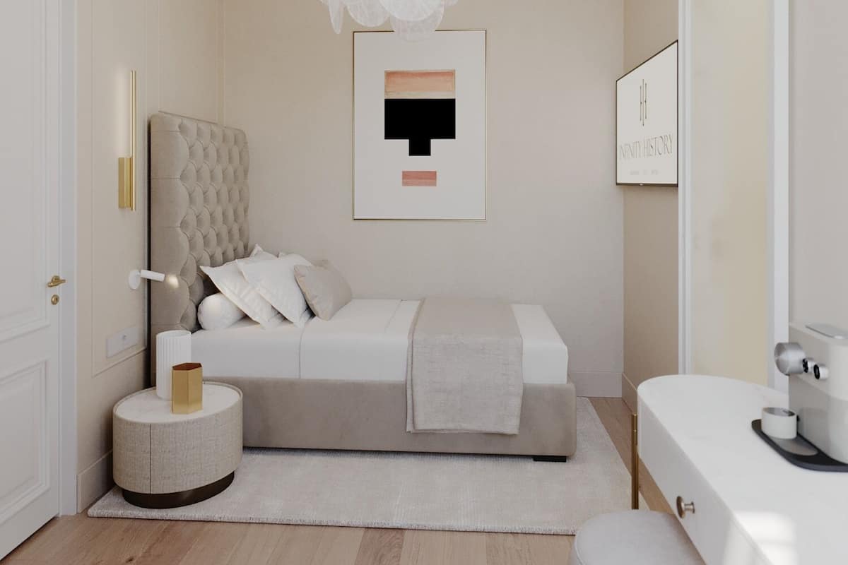 Quarto moderno com cama de cabeceira estofada, mesa de cabeceira redonda, um banco branco e um candelabro exclusivo.