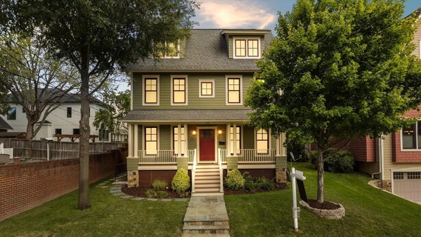 A two-story house with a front porch, a red door, and a well-maintained lawn. - The Houstonia, 3 bedroom single family home near DC (Arlington)