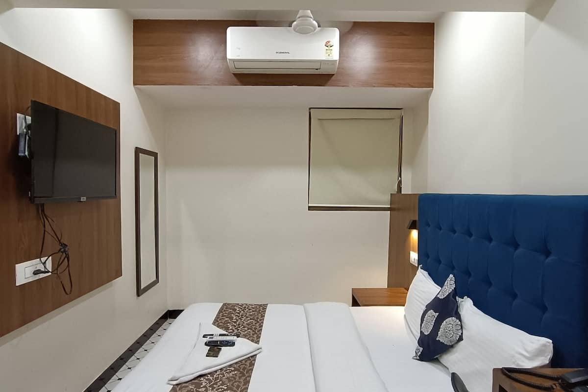 Relax in a stylish room with a comfortable bed, flat-screen TV, and a convenient bedside table.