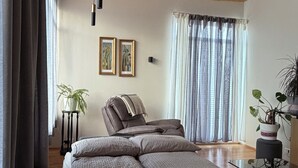 Una camera da letto moderna con un letto, una sedia, una pianta in vaso e un lampadario.