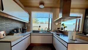 Una cucina moderna con zoccolo in pietra, una macchina da caffè, un tostapane e una finestra vista.