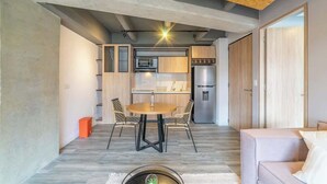 Una cocina moderna con una isla central, electrodomésticos integrados y un comedor con sillas.