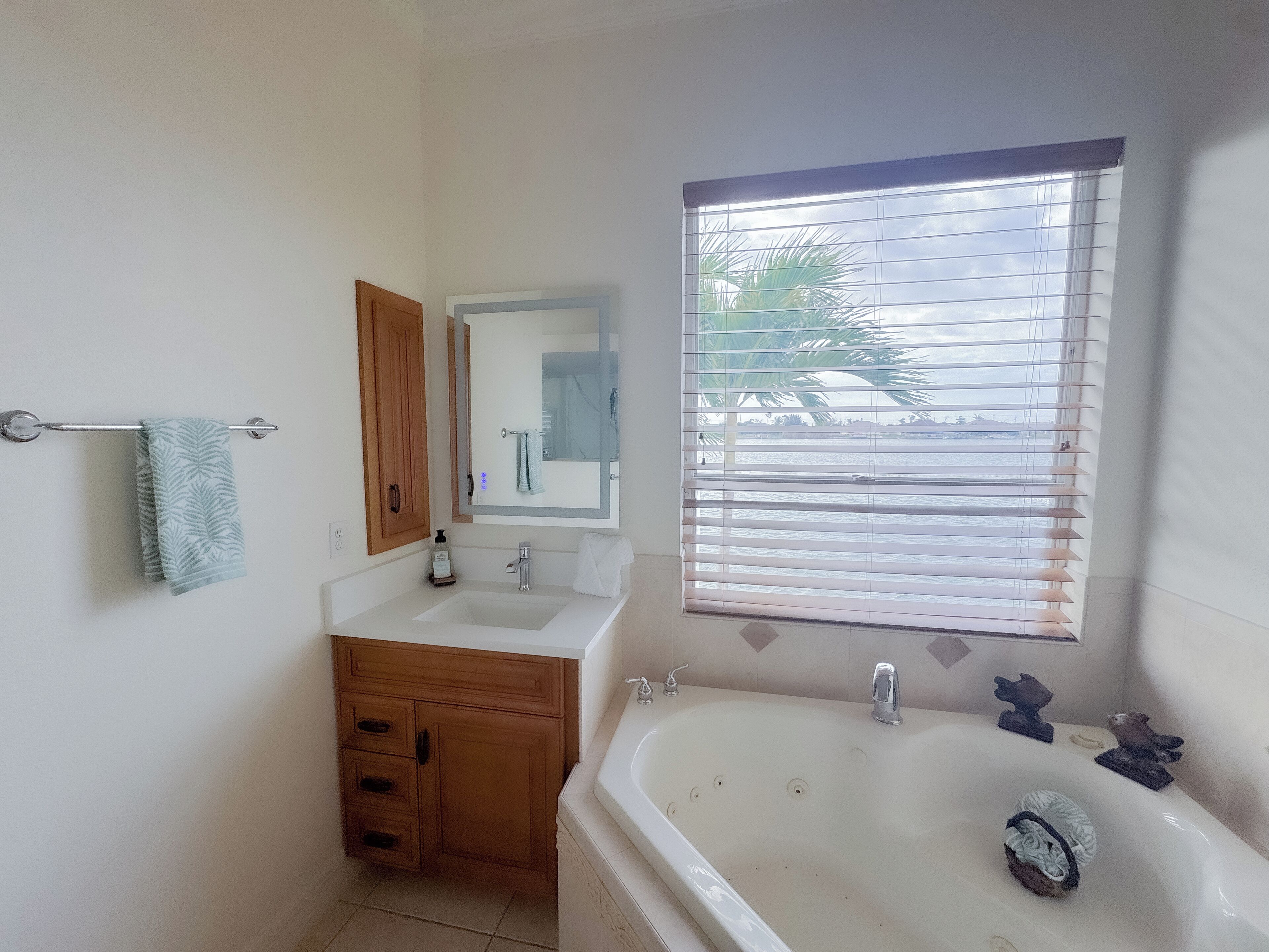 A bathroom with a sink, vanity, and bathtub.