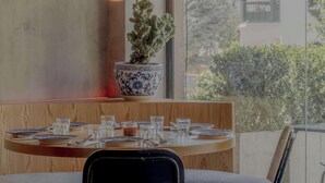 A dining area with a table set for four, a potted plant, and a hanging light fixture. - NOK Bright Loft in Chapinero (Bogotá)