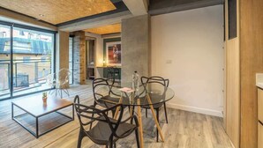 A modern interior with a glass dining table, black chairs, and a wooden floor. - NOK Stunning 1 Br in Chapinero (Bogotá)