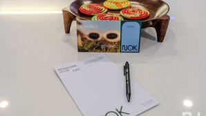 A white table with a pen, a card, and a box of colorful coasters. - NOK Stylish 3BR Apt & Fast Wi-Fi Bogotá (Bogot á)