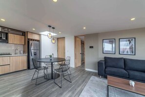 Une cuisine moderne avec un coin repas, un canapé et une table basse.