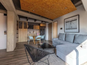 Een moderne woonkamer met een bank, een salontafel en een eethoek met stoelen en een tafel.