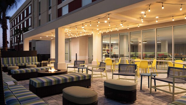 An outdoor seating area with sofas, chairs, and a fire pit. - Home2 Suites By Hilton Winter Haven (Winter Haven)