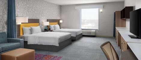 A hotel room with two beds, a desk, a TV, a chair, and a window with a view.