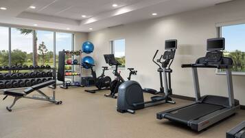 A gym with treadmills, elliptical machines, and free weights.