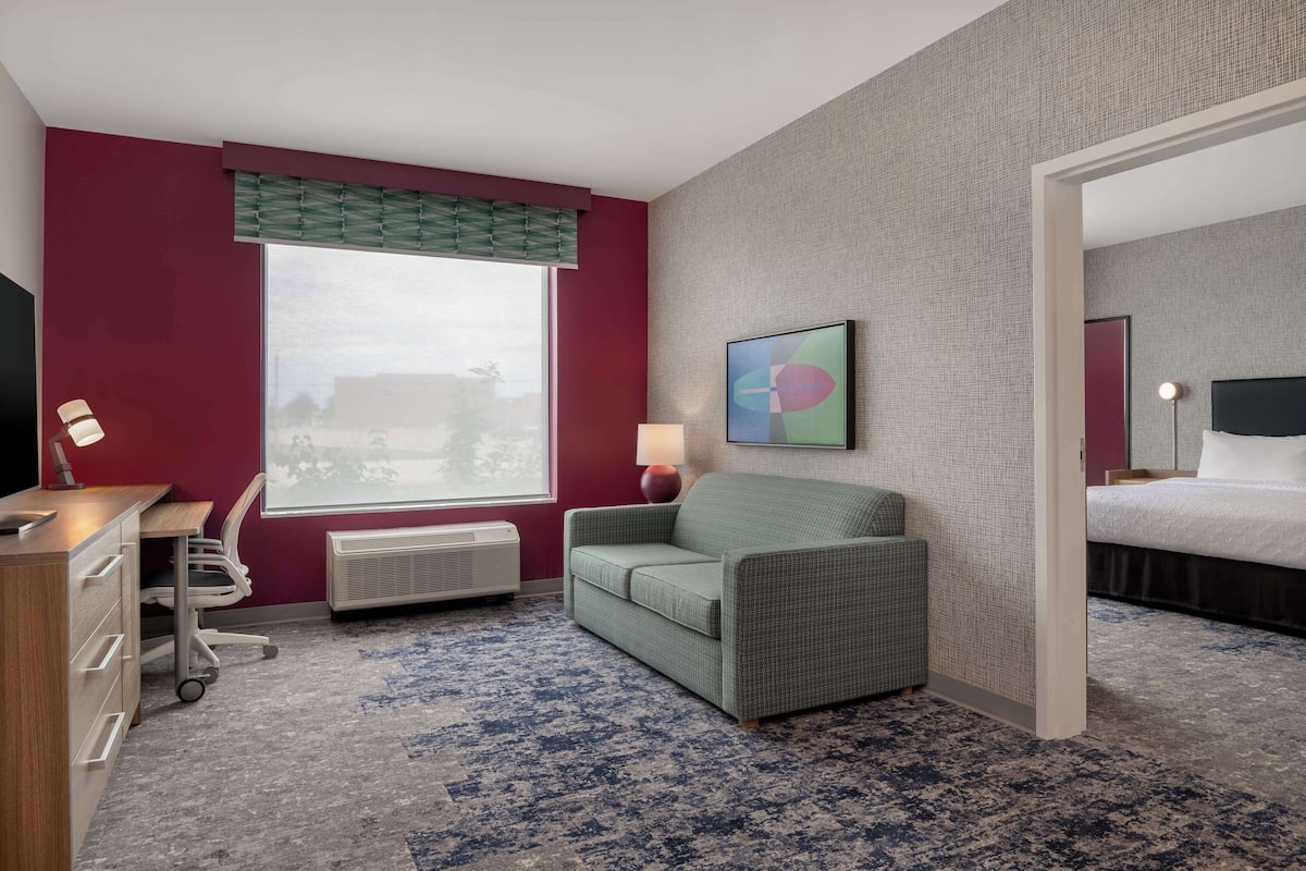 Een hotelkamer met een bureau, stoel en bed.