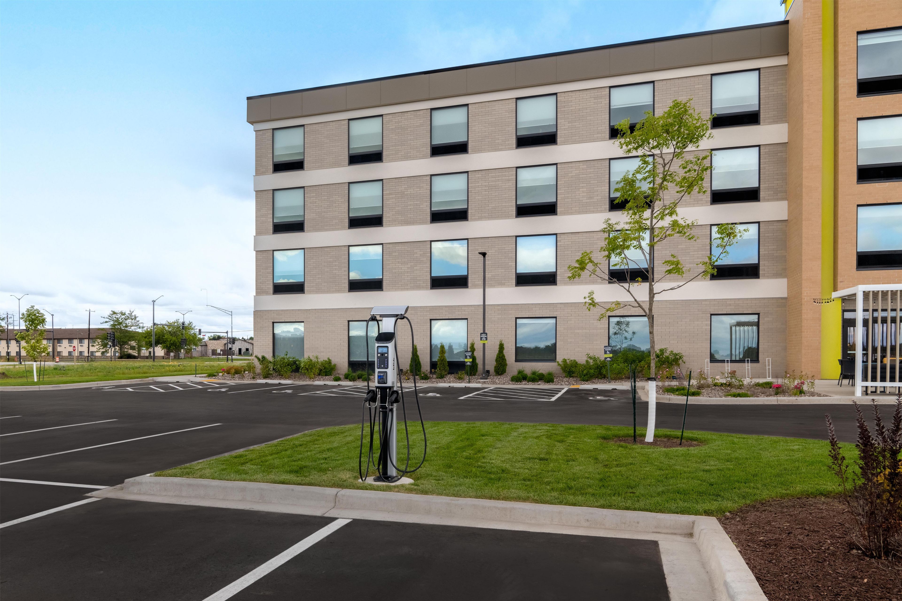 A modern building with a parking lot and a solar-powered charging station.