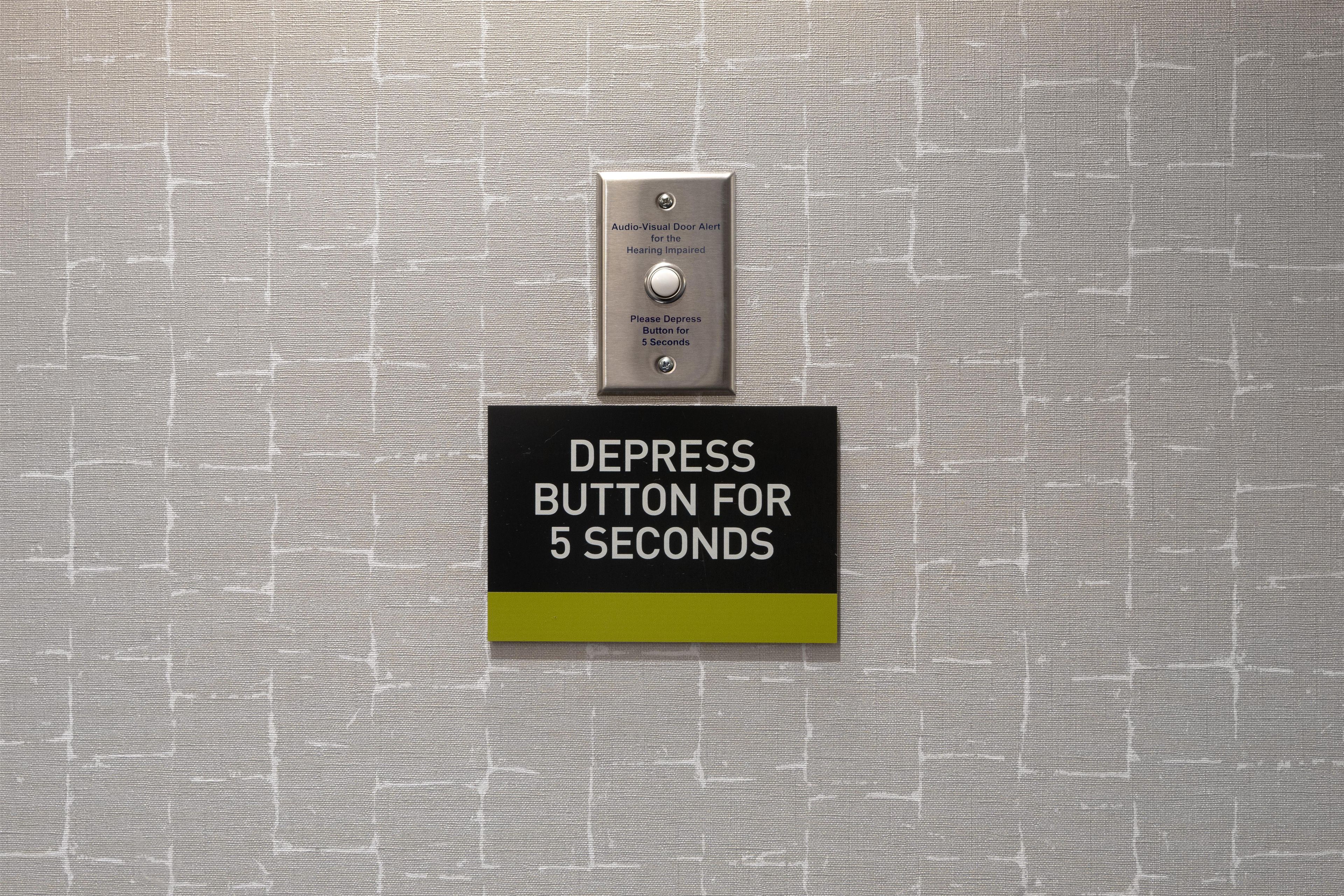A depression button for 5 seconds on a textured wall.
