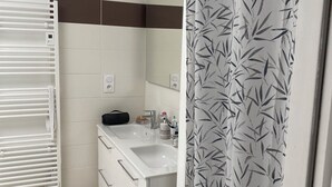 A bathroom with a white sink, mirror, and towel rack. - Homestay for rent.  House in a very quiet subdivision. (Les Essarts)