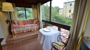 Una habitación acogedora con un sofá, una mesa con un plato y una silla.