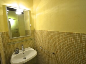 A bathroom with a sink, mirror, and tiled walls.
