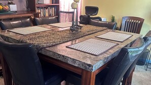 A dining area with a large wooden table, black leather chairs, and a bookshelf in the background. - Colorful spacious 3 bedroom house near center  (Philadelphia)