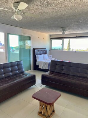 Apartament, diversos llits, cuina bàsica, vistes a la ciutat | Sala d'estar | Televisor intel·ligent de 42 polzades amb canals per cable