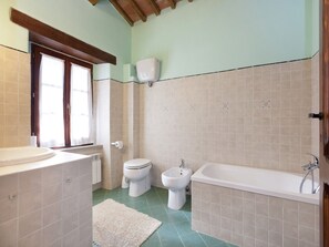 Een badkamer met een wastafel, toilet, bidet en bad.