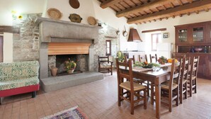 A rustic interior with a stone fireplace, wooden dining table, and chairs. - Farmhouse in Apecchio with Pool & Spa (Apecchio)