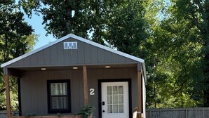 A small, single-story building with a white door and a number '2' sign.