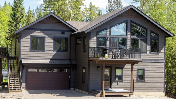 A two-story house with a garage, a balcony, and a large window. - Newly Built 2 Bedrooms. Sleeps 4 Adults. AC (Fernie)