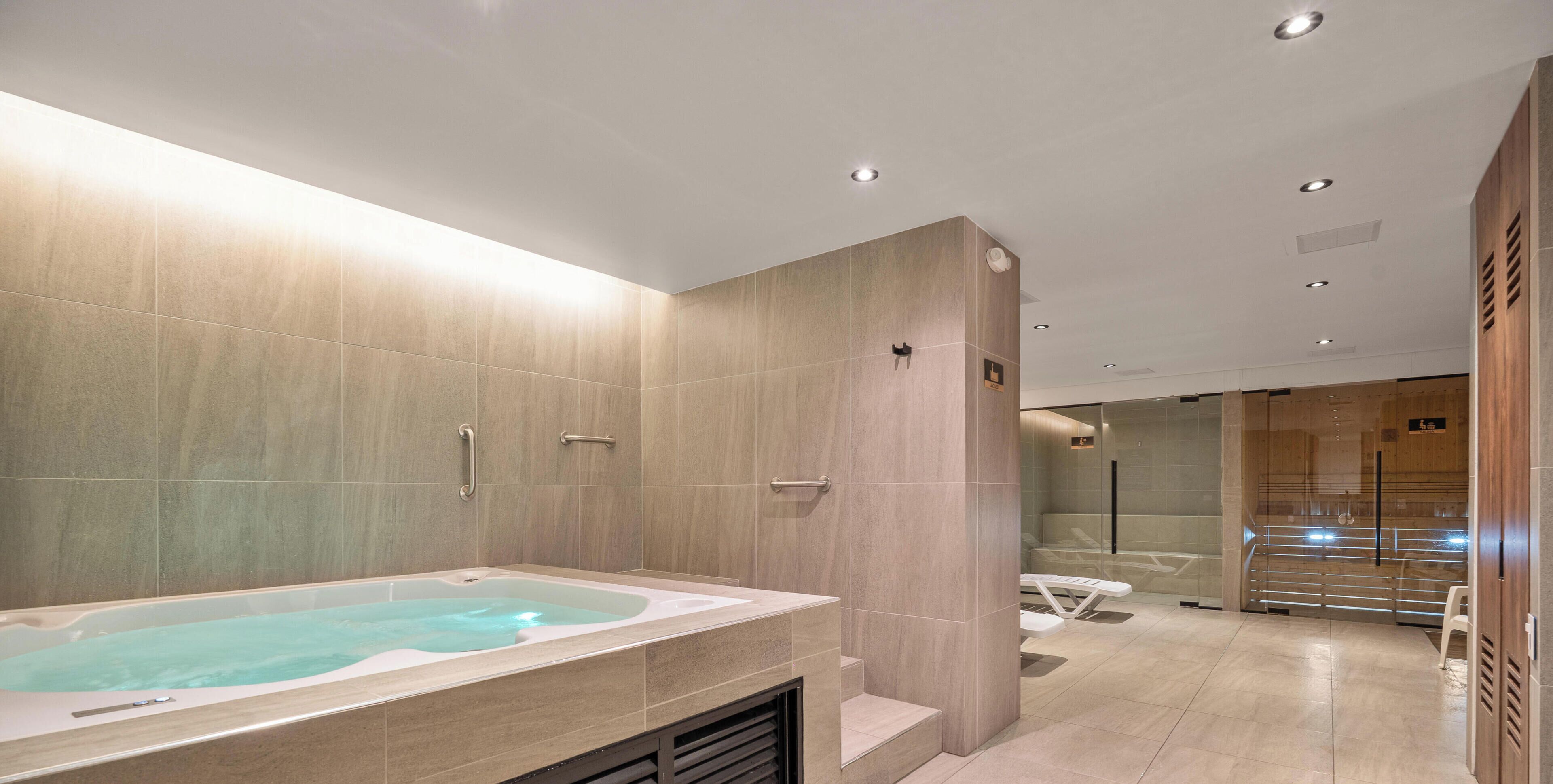 Un baño moderno con una bañera grande, zona de ducha y tocador con espejo.