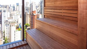 A high-rise building with a wooden bench and a view of the cityscape. - Movinn Nine - Jardim Paulista (São Paulo)