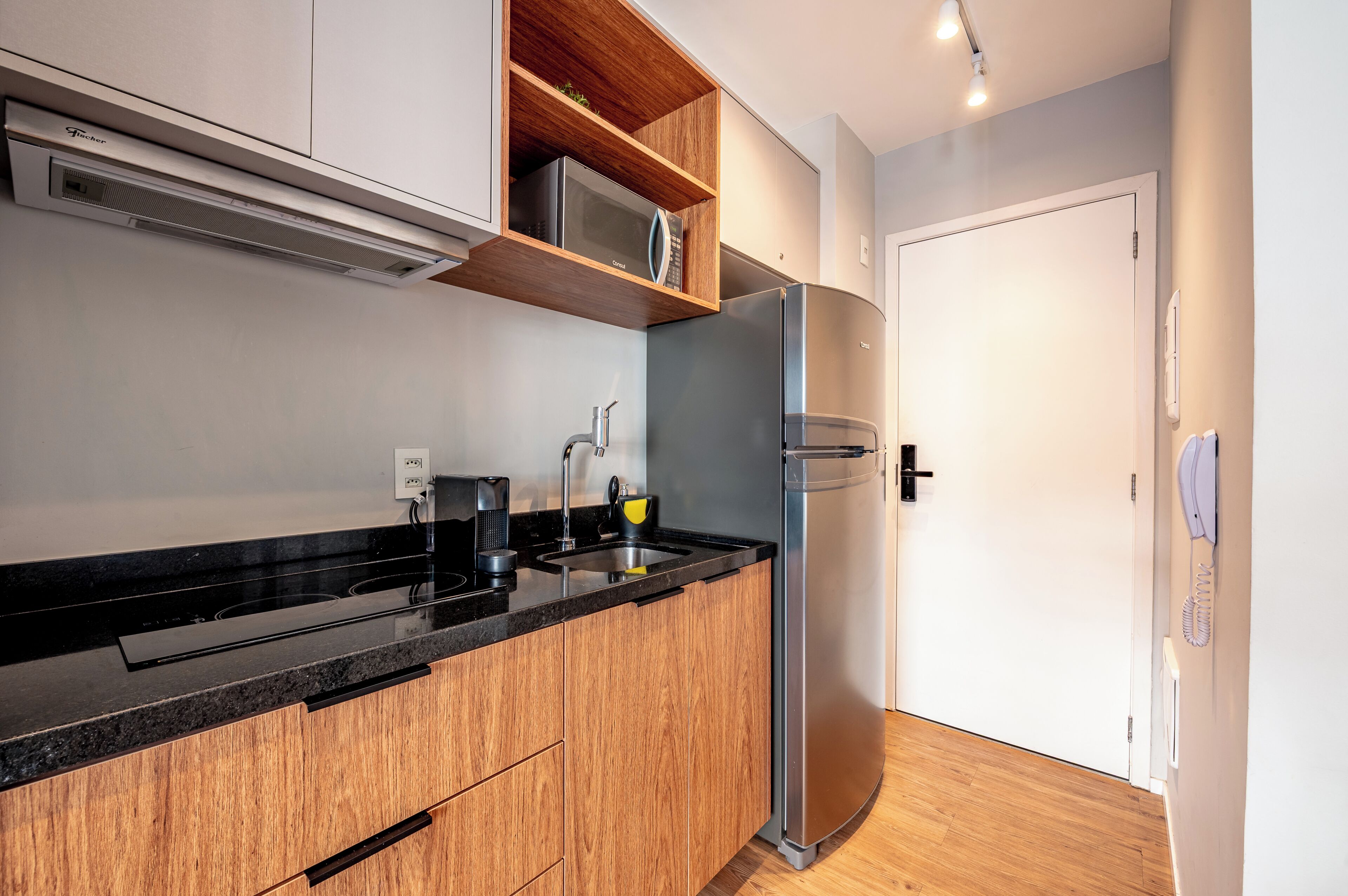 A modern kitchen with a built-in microwave, stainless steel appliances, and wooden cabinetry.