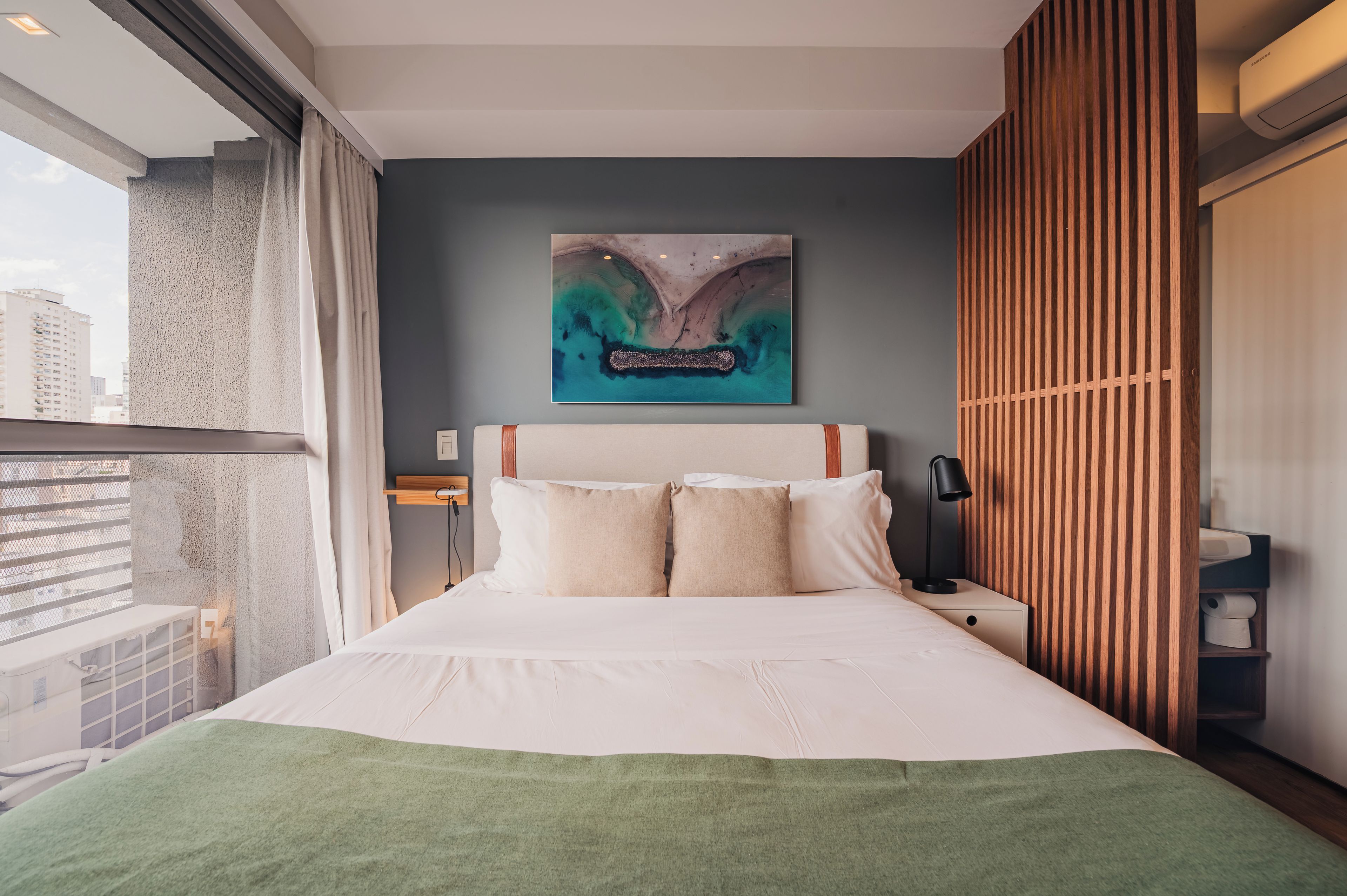 Une chambre d’hôtel avec un grand lit, une vue sur la ville et un design moderne.
